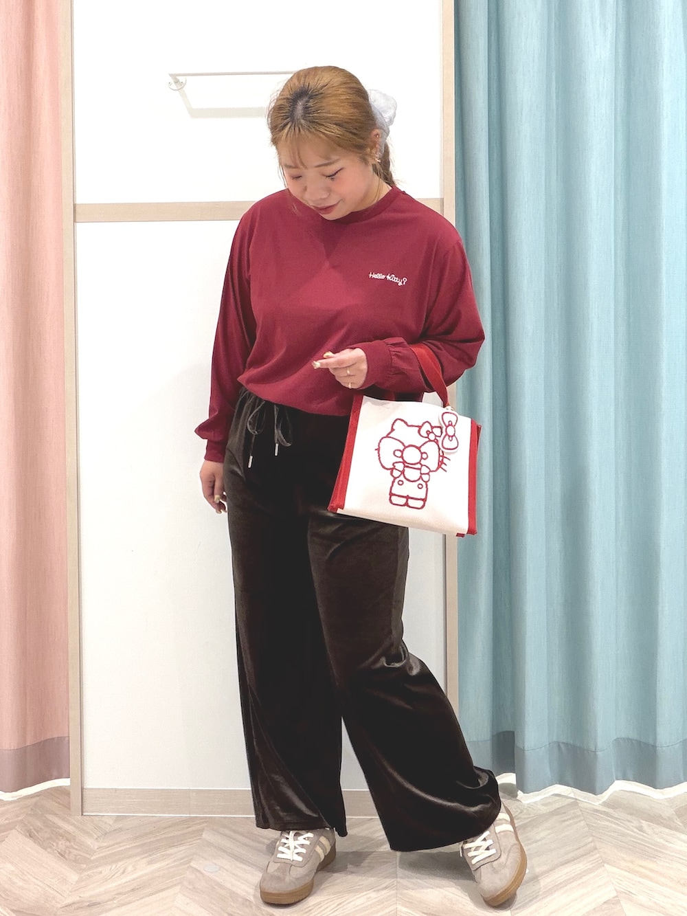 レッド系のTシャツ/カットソー、ブラウン系のその他パンツ、ベージュ系のスニーカーを着用したレディースの秋コーディネートの3枚目の写真