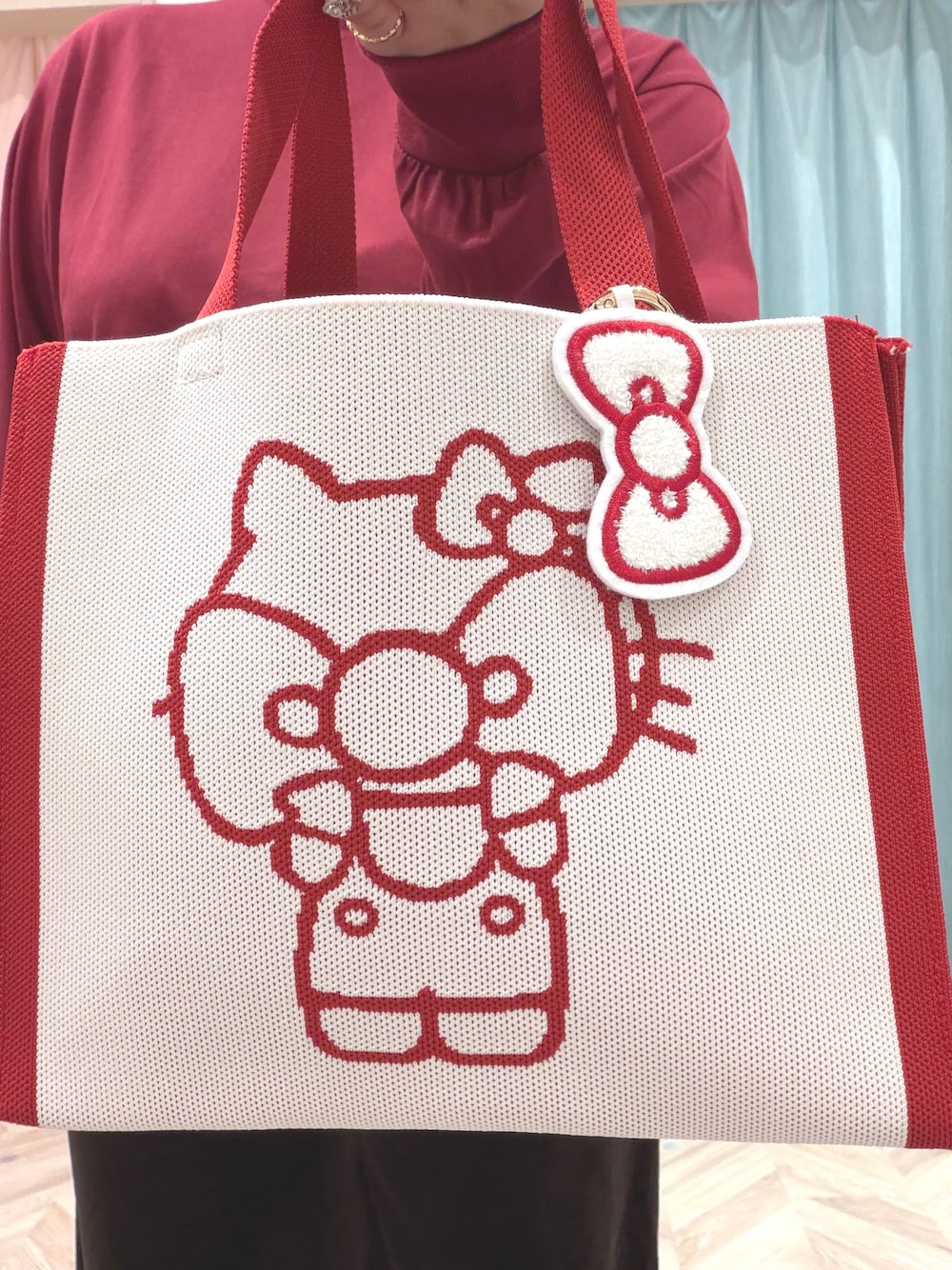 レッド系のTシャツ/カットソー、ブラウン系のその他パンツ、ベージュ系のスニーカーを着用したレディースの秋コーディネートの9枚目の写真