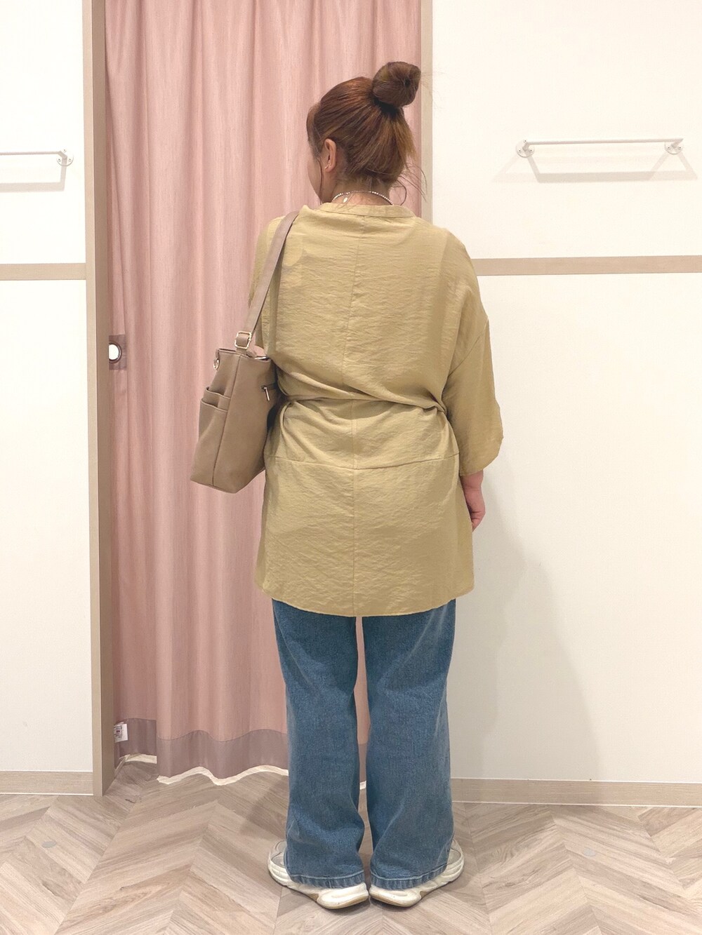 イエロー系のワンピース、ブルー系のデニムパンツ、ベージュ系のショルダーバッグを着用したレディースの夏コーディネートの5枚目の写真