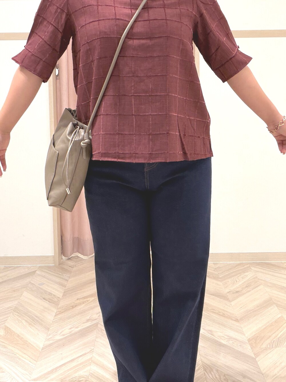 レッド系のシャツ/ブラウス、ブルー系のデニムパンツ、ブラウン系のパンプスを着用したレディースの夏コーディネートの6枚目の写真