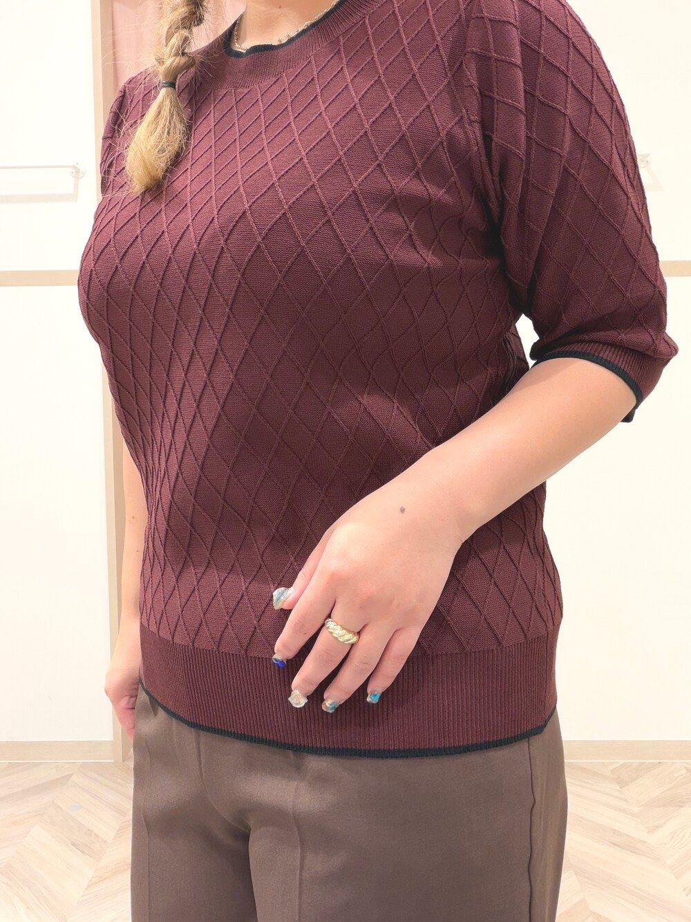 レッド系のニット/セーター、ブラウン系のその他パンツ、ブラック系のその他シューズを着用したレディースの夏コーディネートの6枚目の写真