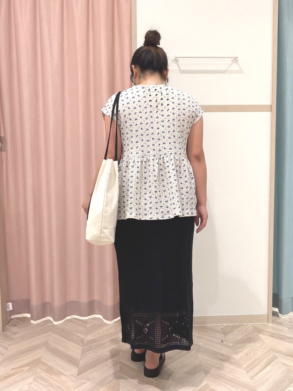 グレー系のTシャツ/カットソー、ブラック系のスカート、ホワイト系のトートバッグを着用したレディースの夏コーディネートの6枚目の写真