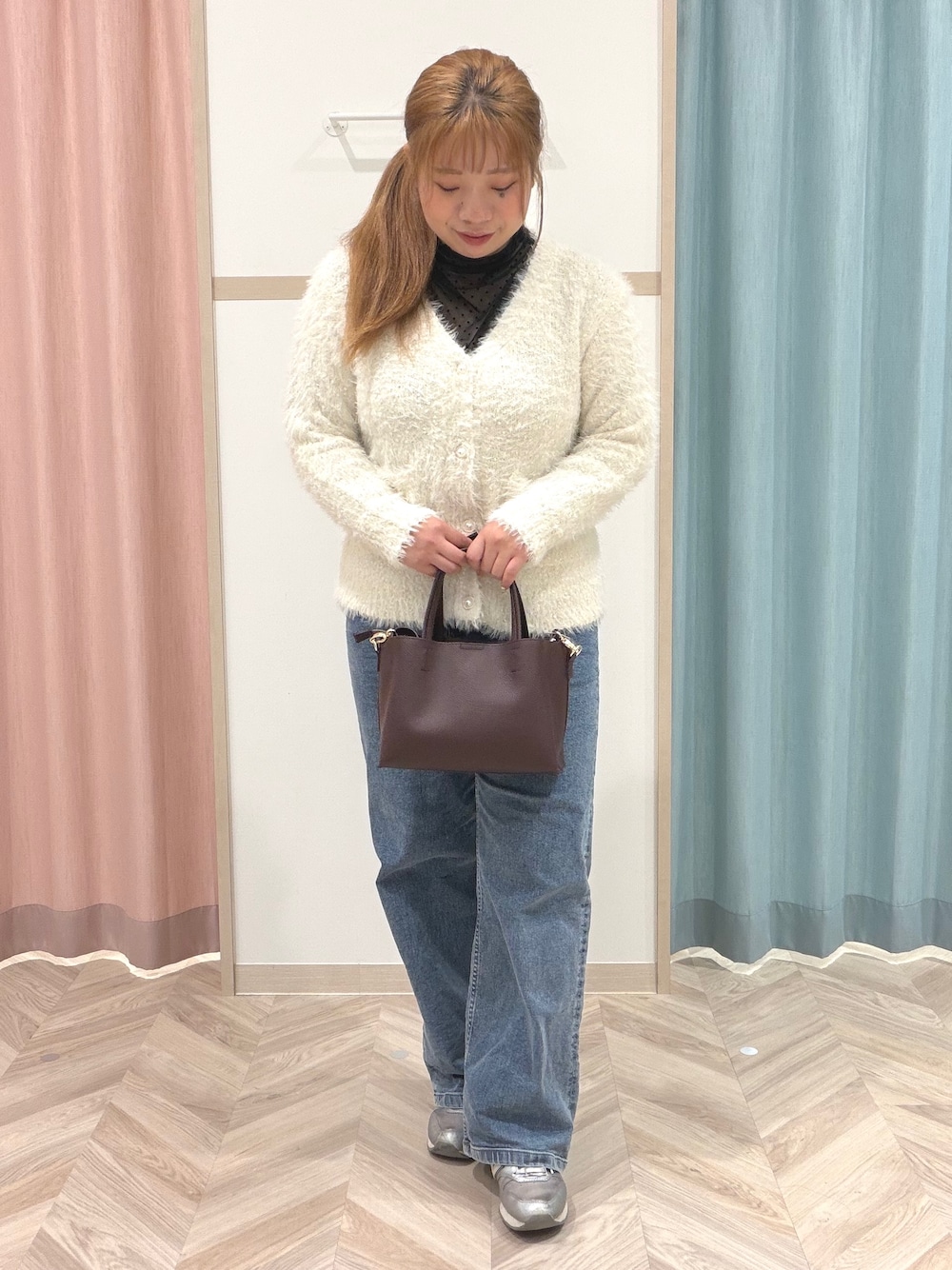 ブラック系のTシャツ/カットソー、ホワイト系のニット/セーター、ブルー系のデニムパンツを着用したレディースの秋コーディネートの3枚目の写真
