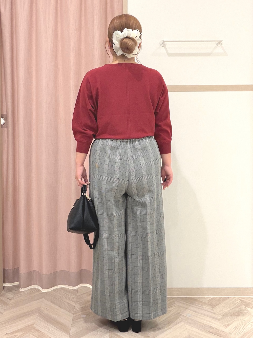 レッド系のニット/セーター、グレー系のその他パンツ、ブラック系のブーツを着用したレディースの秋コーディネートの5枚目の写真