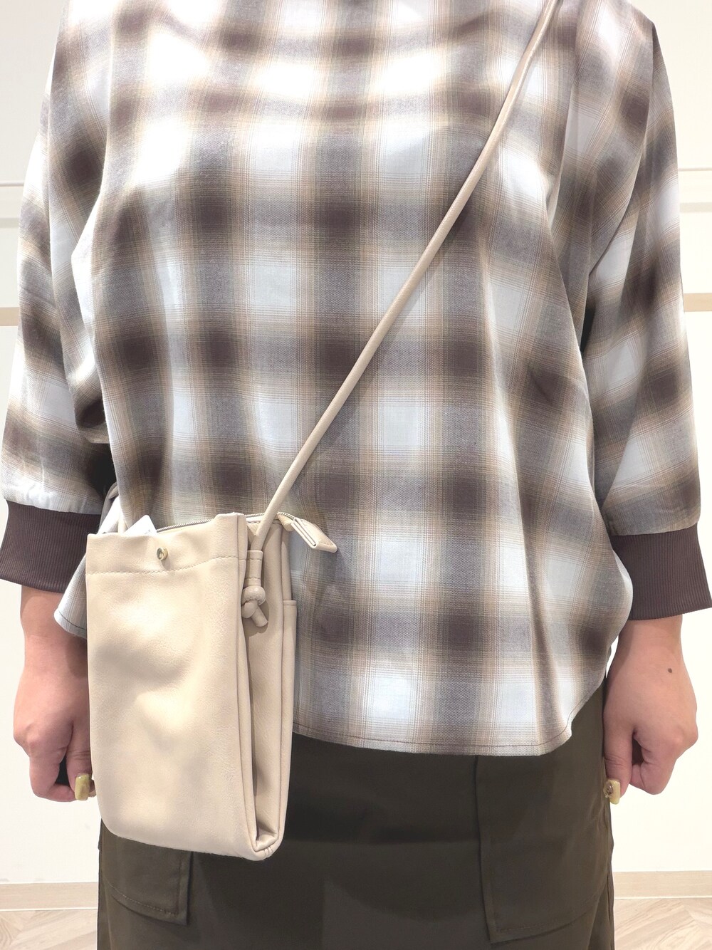 ベージュ系のシャツ/ブラウス、ブラック系のブーツ、ベージュ系のショルダーバッグを着用したレディースの秋コーディネートの9枚目の写真