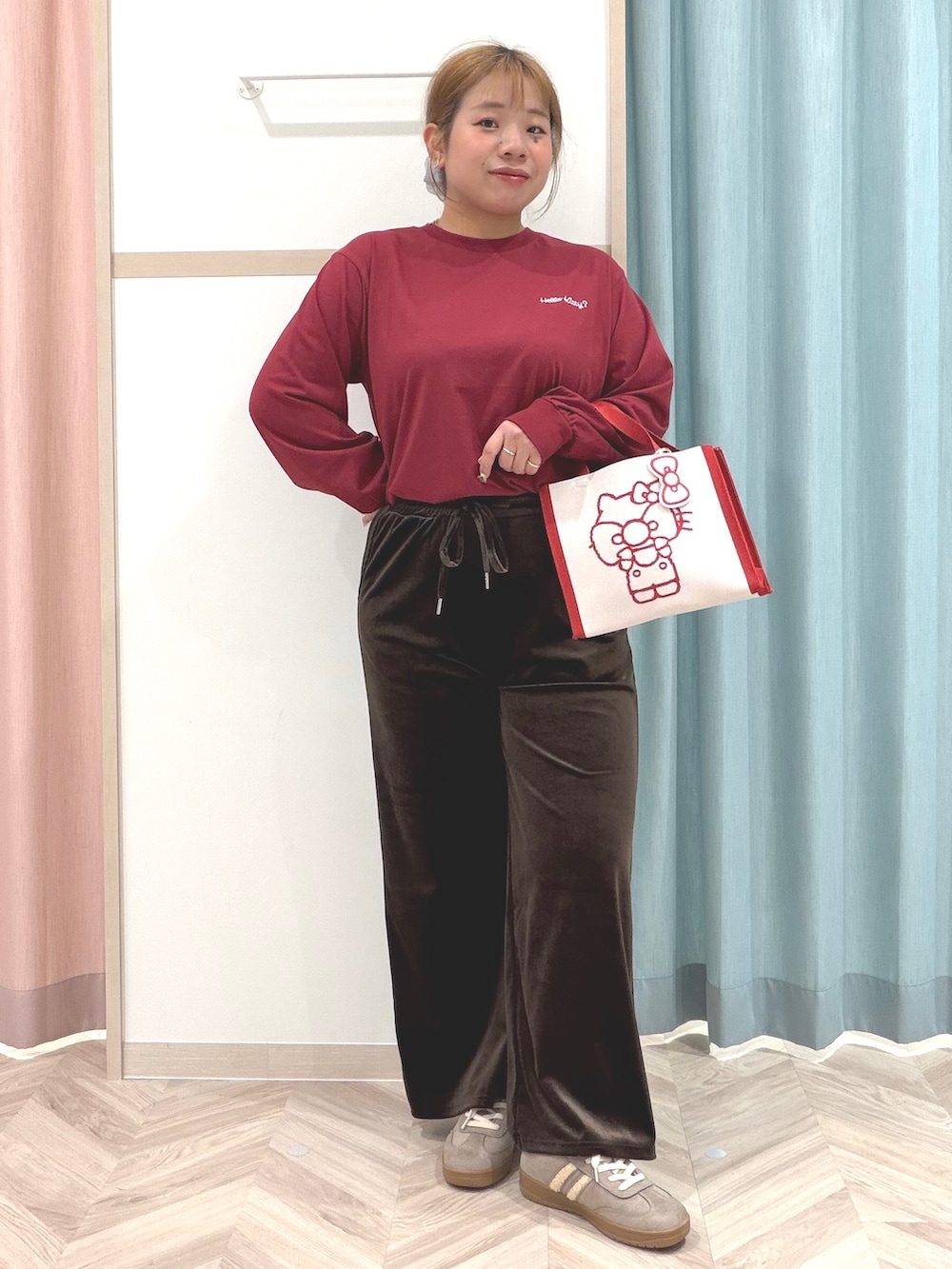 レッド系のTシャツ/カットソー、ブラウン系のその他パンツ、ベージュ系のスニーカーを着用したレディースの秋コーディネートの2枚目の写真