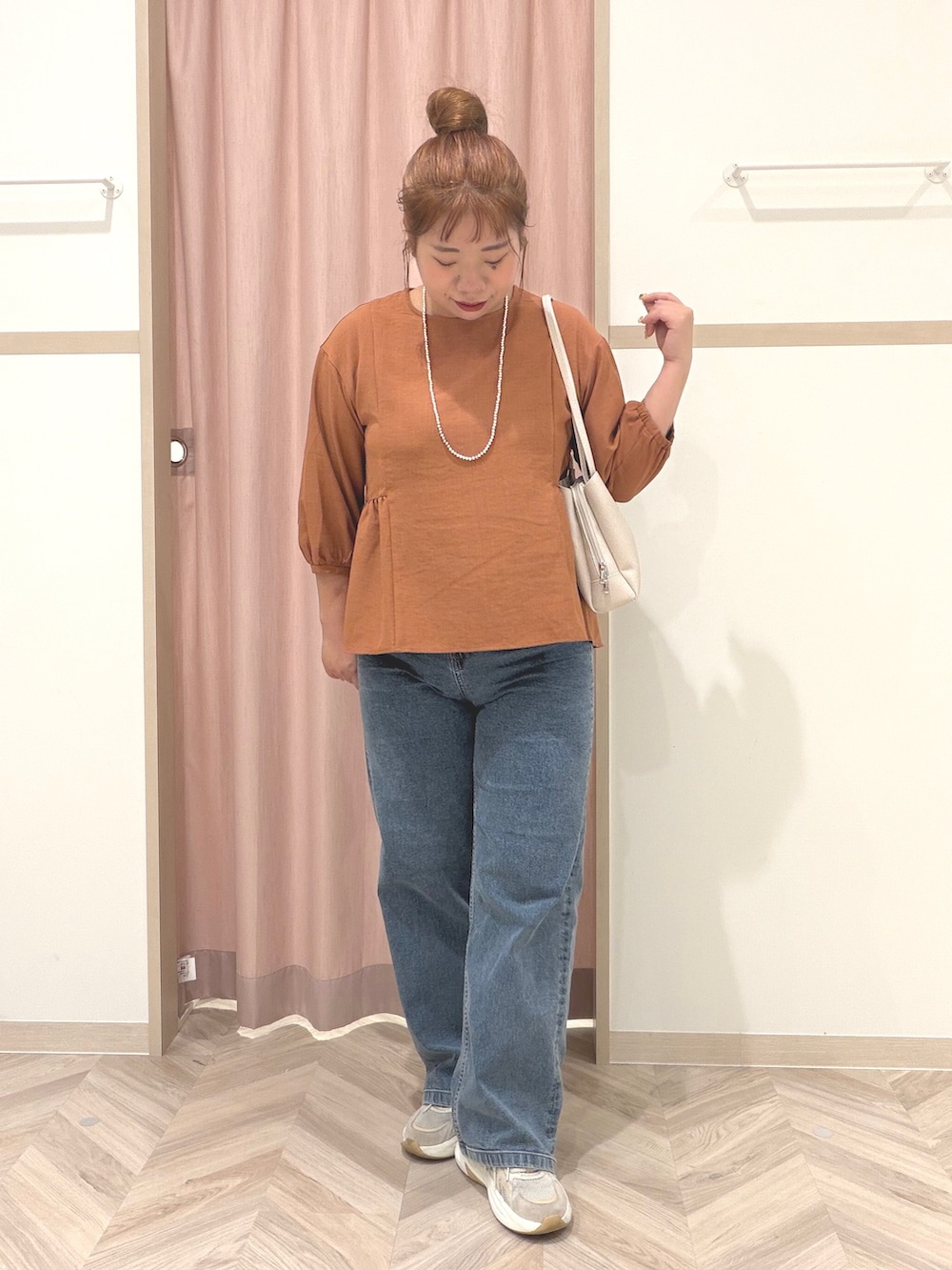レッド系のシャツ/ブラウス、ブルー系のデニムパンツ、ベージュ系のショルダーバッグを着用したレディースの夏コーディネートの2枚目の写真