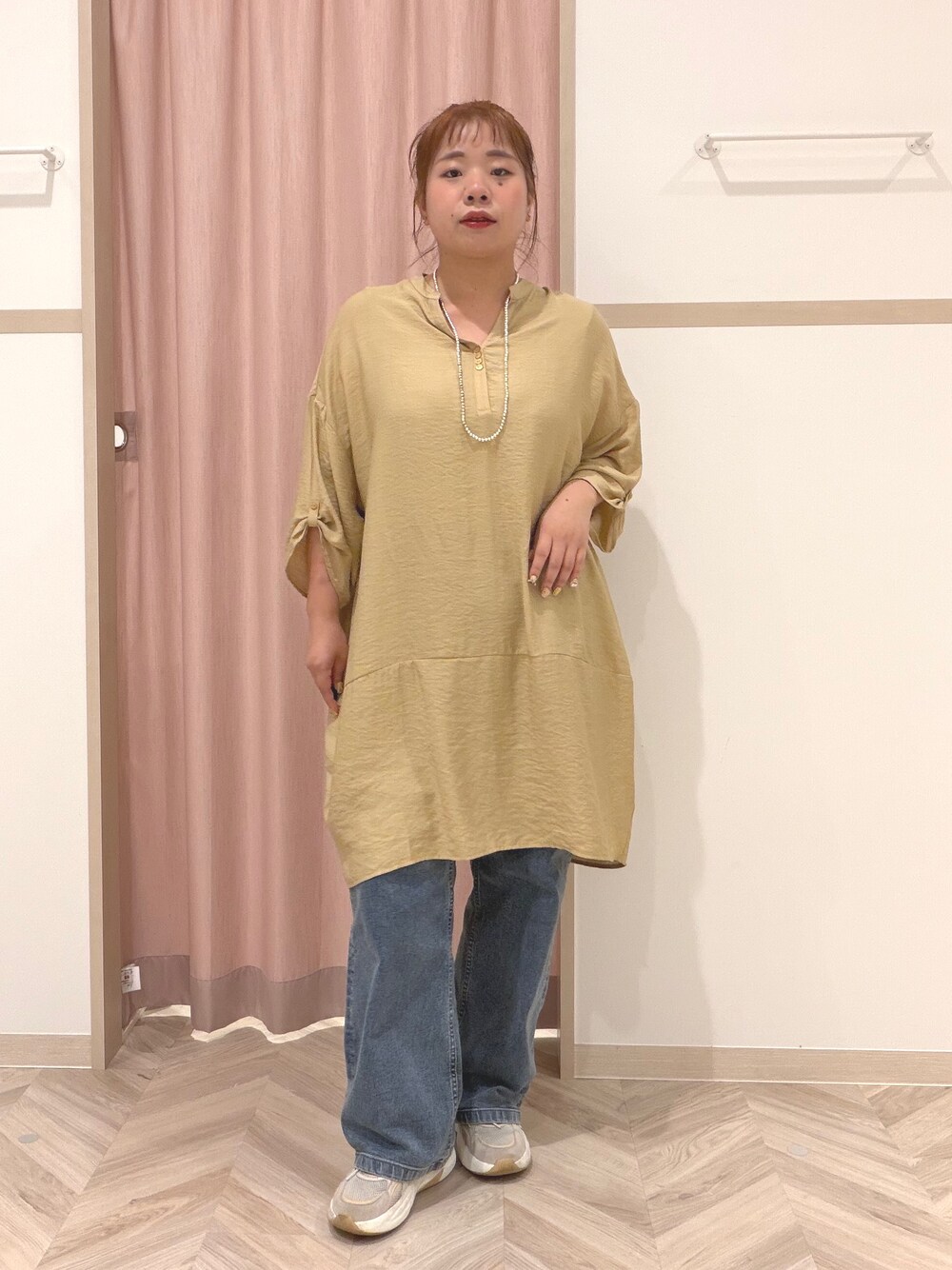 イエロー系のワンピース、ブルー系のデニムパンツ、ベージュ系のショルダーバッグを着用したレディースの夏コーディネートの7枚目の写真
