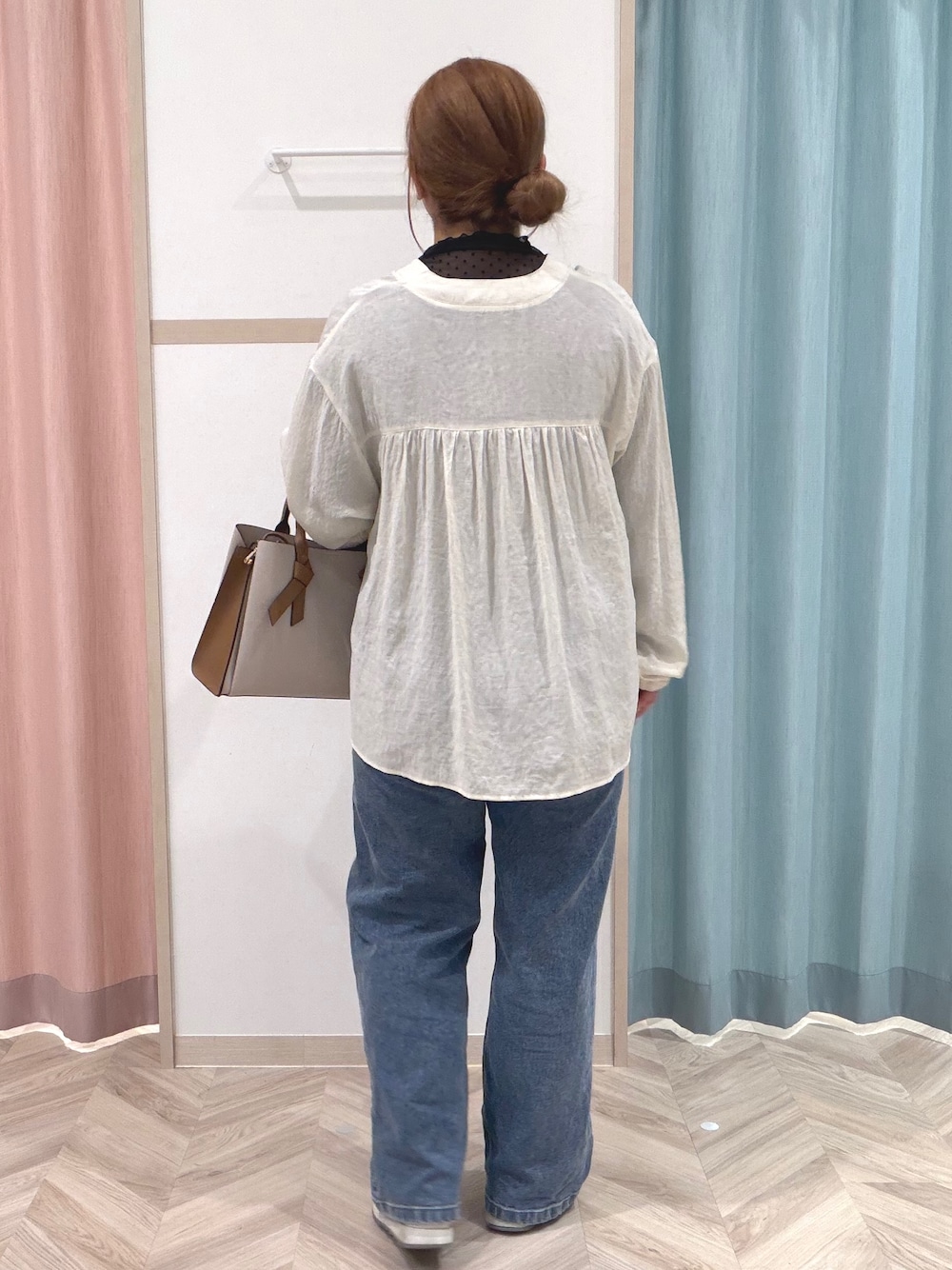 ブラック系のTシャツ/カットソー、ホワイト系のカーディガン/ボレロ、ブルー系のデニムパンツを着用したレディースの秋コーディネートの6枚目の写真