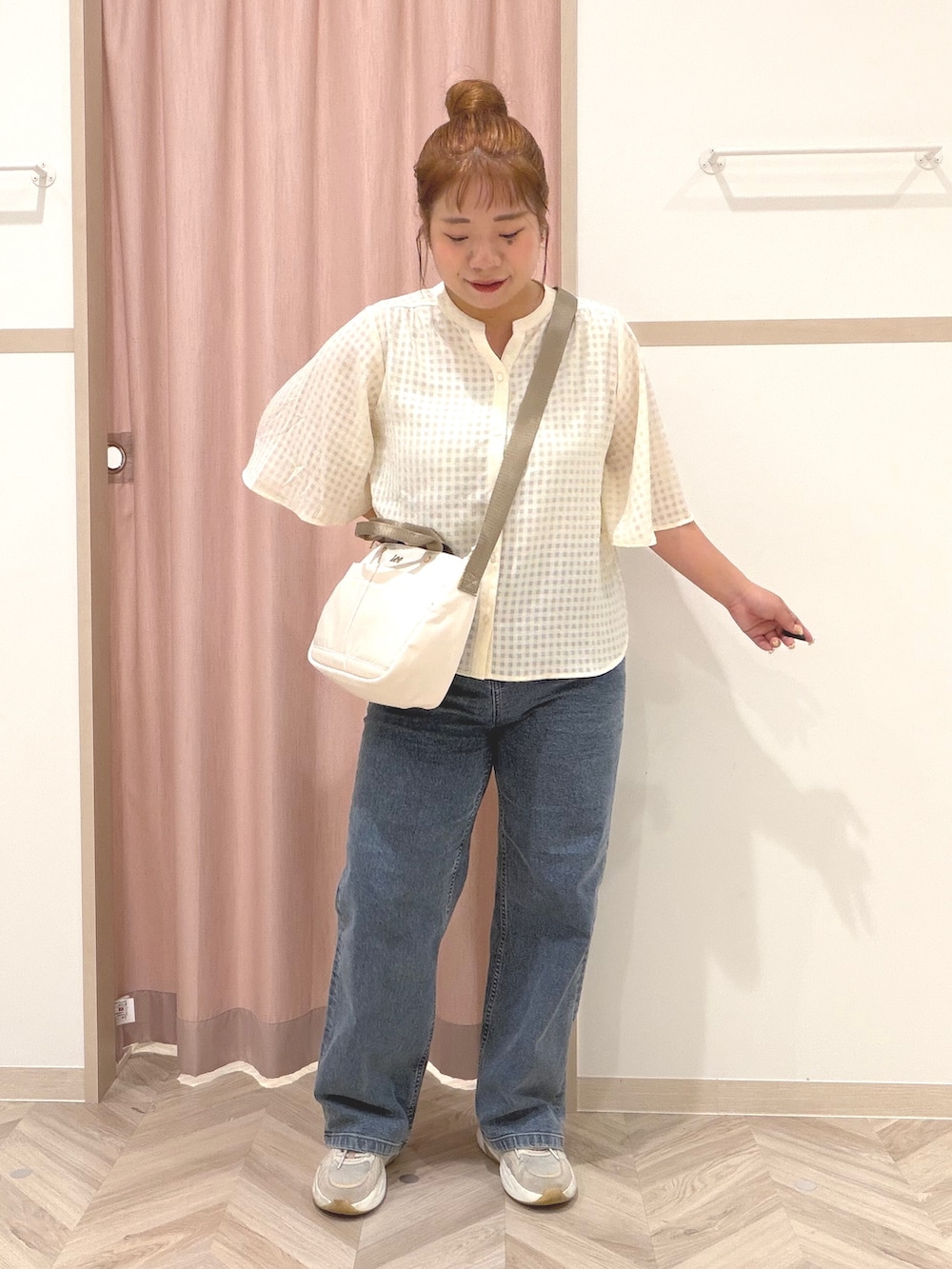 ゴールド系のタンクトップ、ホワイト系のシャツ/ブラウス、ブルー系のデニムパンツを着用したレディースの夏コーディネートの2枚目の写真