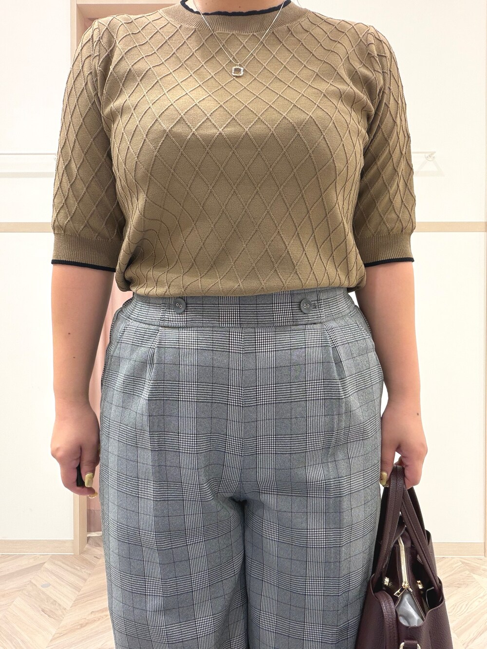 ベージュ系のニット/セーター、グレー系のその他パンツ、ブラック系のブーツを着用したレディースの秋コーディネートの8枚目の写真
