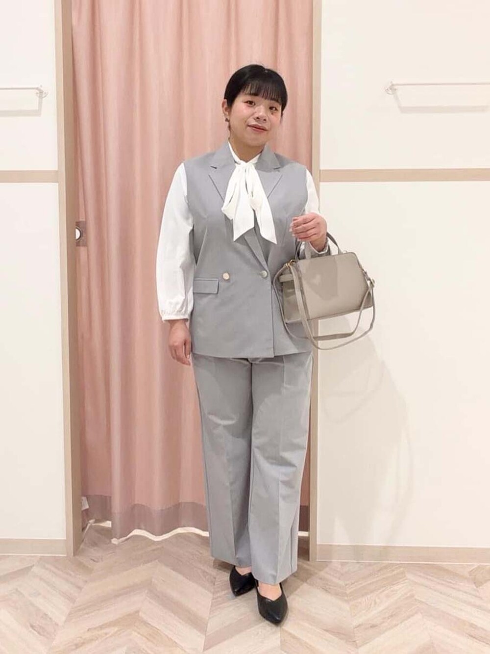 グレー系のベスト、ホワイト系のシャツ/ブラウス、グレー系のその他パンツを着用したレディースの冬コーディネートの2枚目の写真