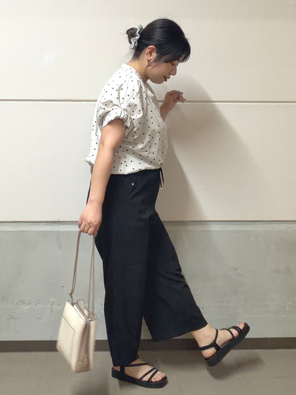 ブラック系のその他パンツ、ブラック系のサンダル、ベージュ系のショルダーバッグを着用したレディースの春コーディネートの2枚目の写真