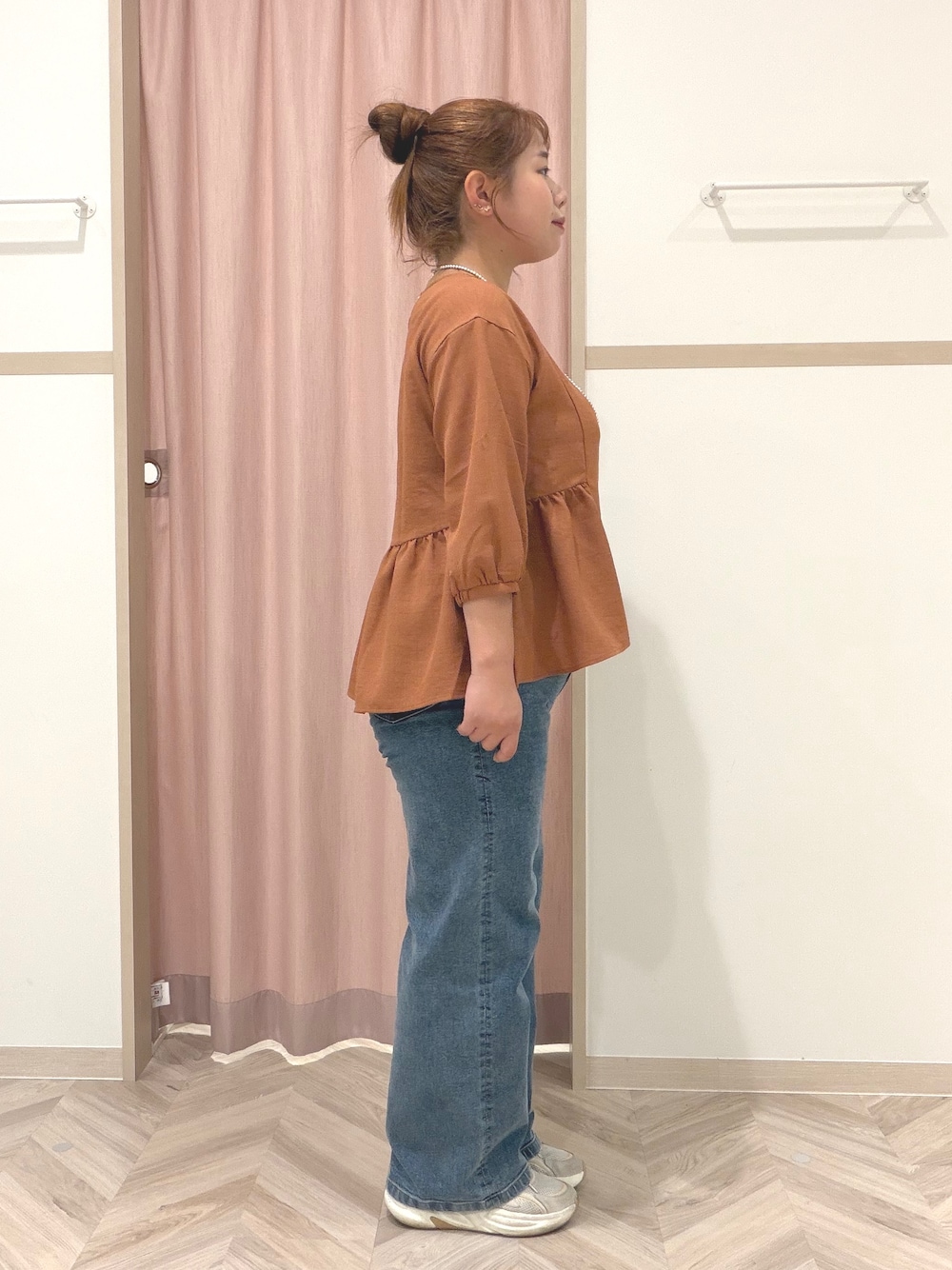 レッド系のシャツ/ブラウス、ブルー系のデニムパンツ、ベージュ系のショルダーバッグを着用したレディースの夏コーディネートの3枚目の写真