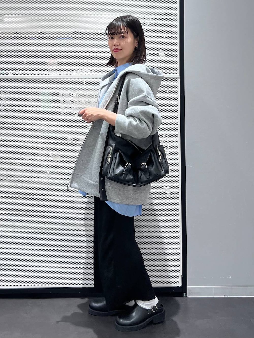 グレー系のパーカー、ブラック系のショルダーバッグ、ブラック系のサンダルを着用したレディースの春コーディネートの3枚目の写真