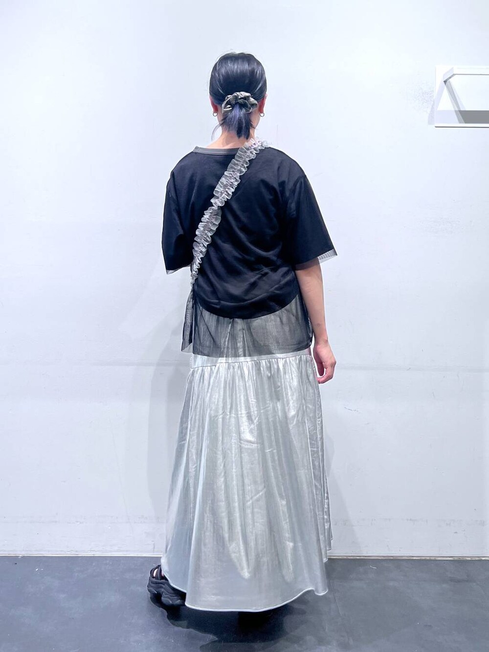 ブラック系のサンダル、シルバー系のスカート、ブラック系のTシャツ/カットソーを着用したレディースの春コーディネートの5枚目の写真