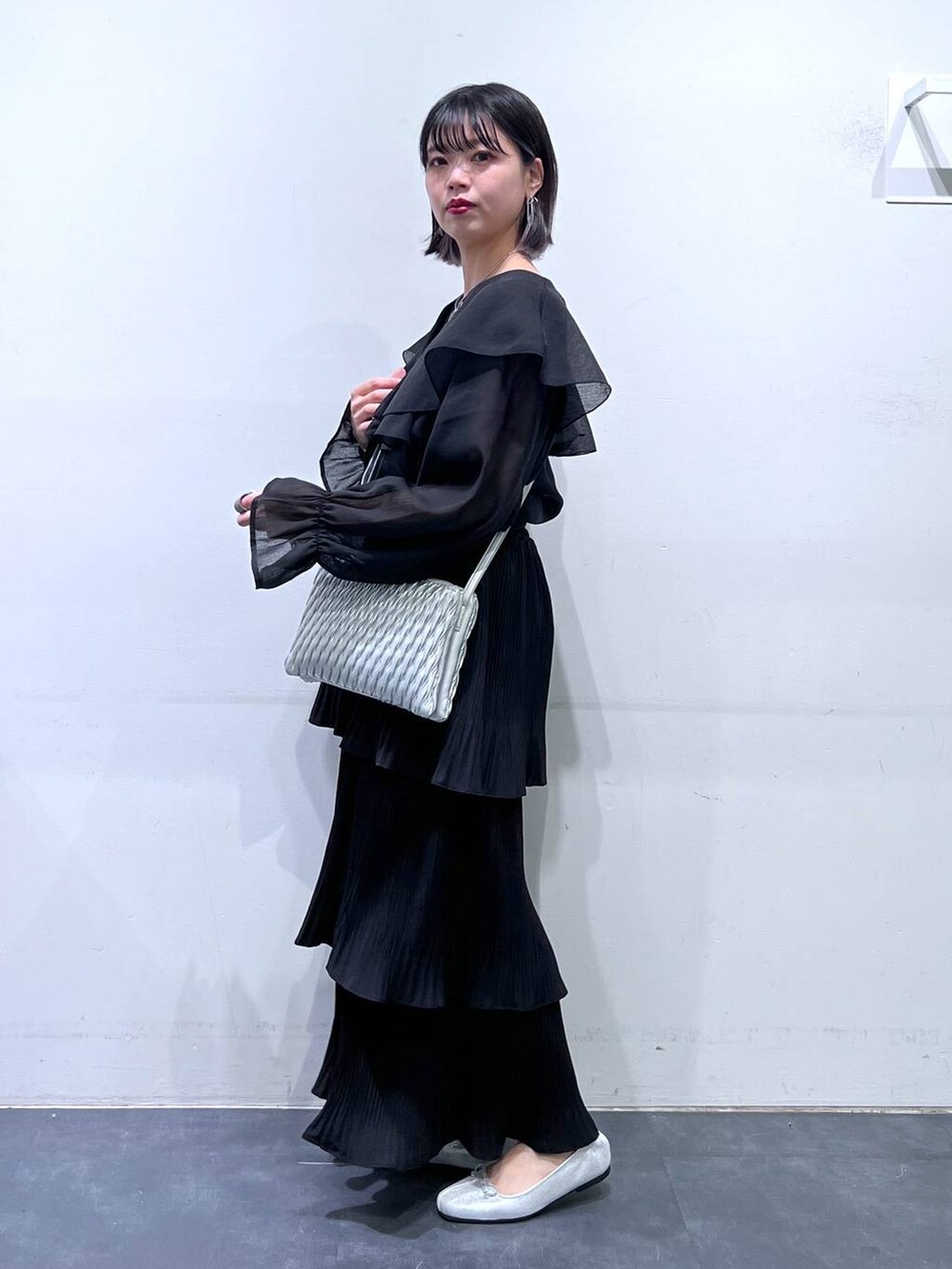 その他のショルダーバッグ、シルバー系のバレエシューズ、ブラック系のスカートを着用したレディースの春コーディネートの5枚目の写真