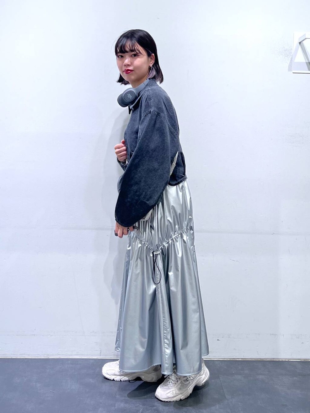 グレー系のデニムジャケット、シルバー系のスカート、ホワイト系のTシャツ/カットソーを着用したレディースの春コーディネートの3枚目の写真