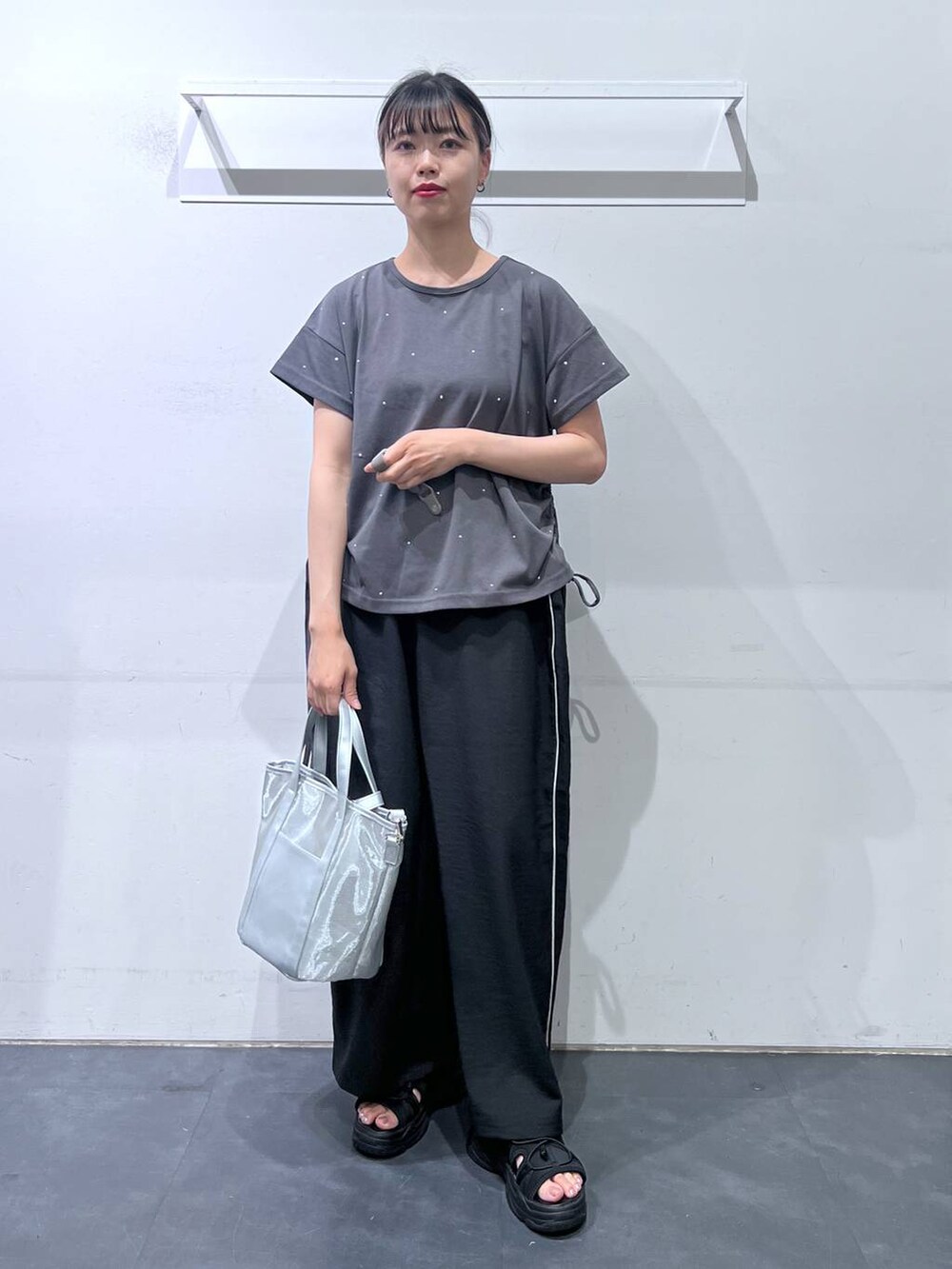 ブラック系のサンダル、ブラック系のその他パンツ、シルバー系のトートバッグを着用したレディースの夏コーディネートの2枚目の写真