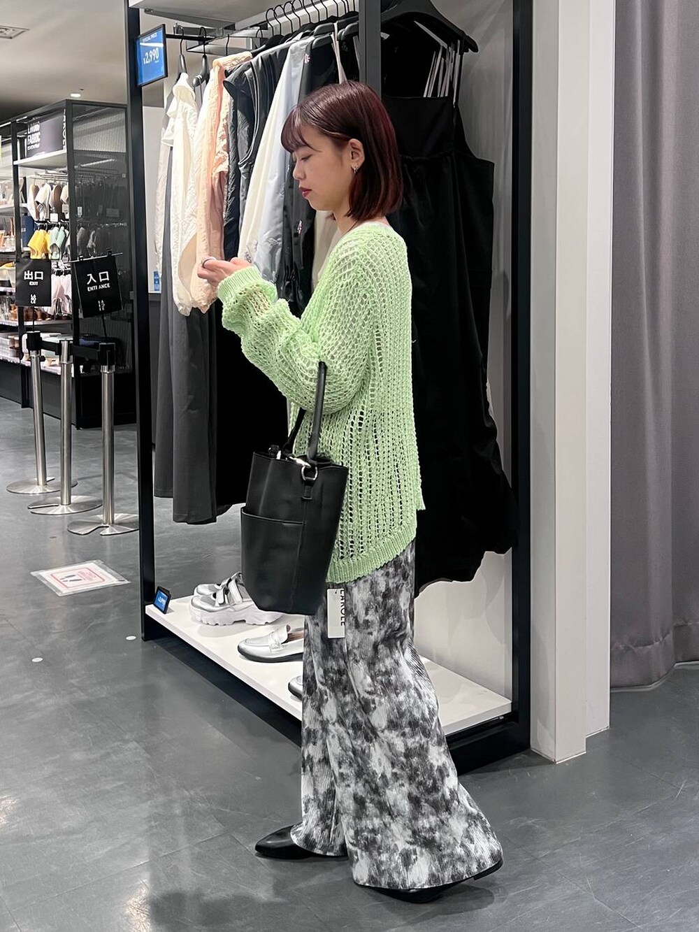 グレー系のTシャツ/カットソー、ブラック系のパンプス、グリーン系のニット/セーターを着用したレディースの春コーディネートの3枚目の写真