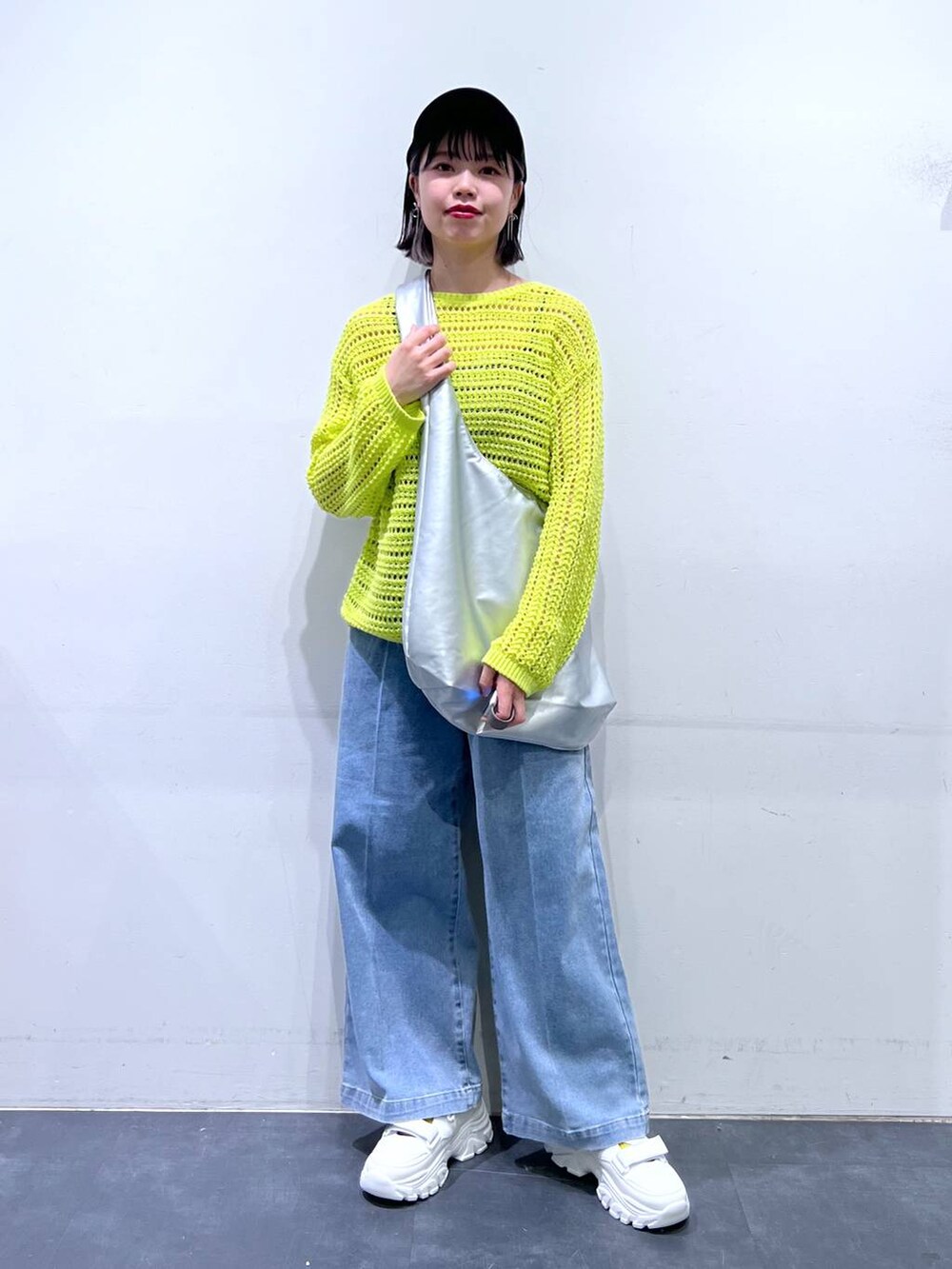 ホワイト系のスニーカー、ブルー系のデニムパンツ、ホワイト系のキャミソールを着用したレディースの春コーディネートの2枚目の写真