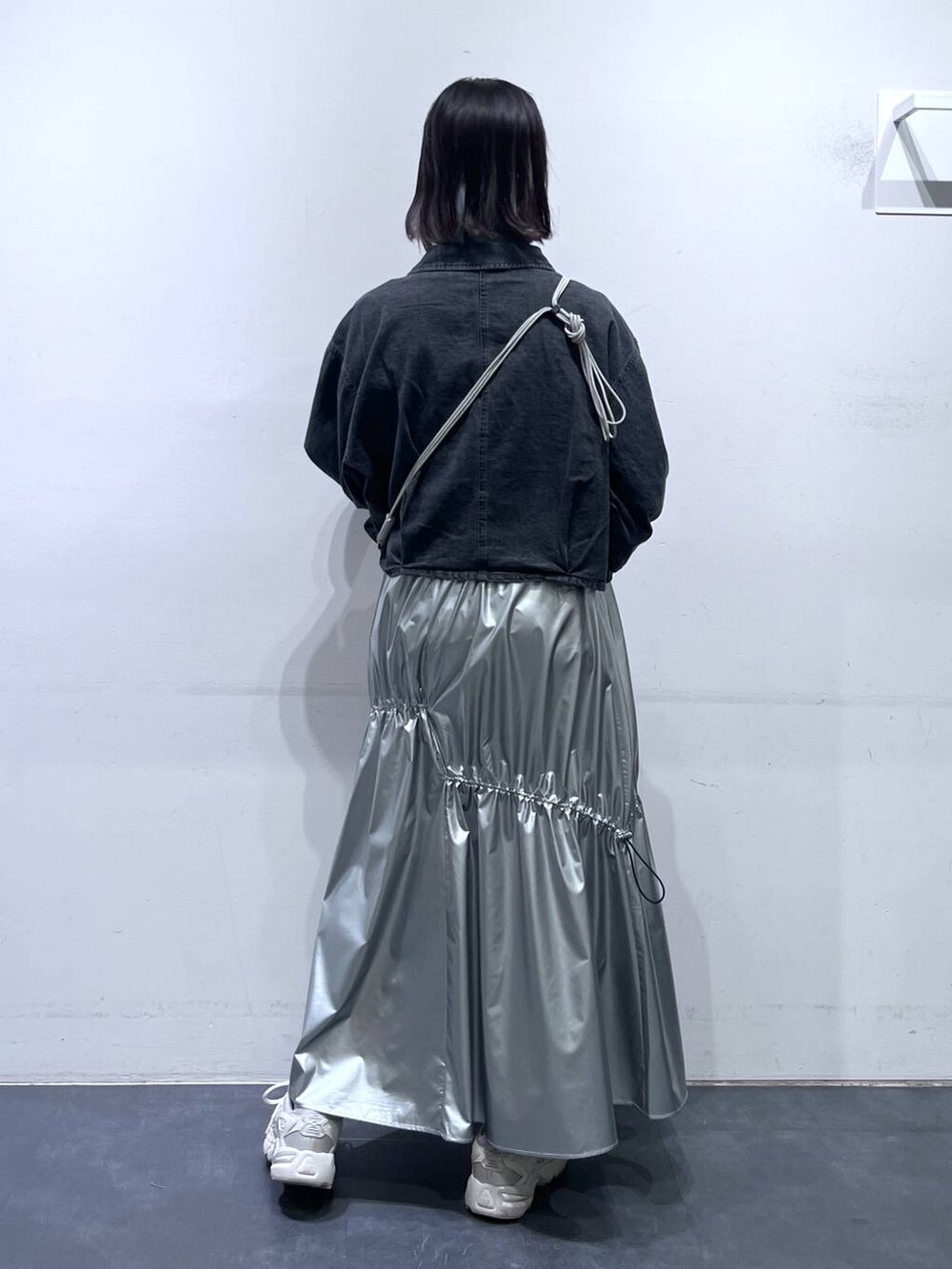 グレー系のデニムジャケット、シルバー系のスカート、ホワイト系のTシャツ/カットソーを着用したレディースの春コーディネートの4枚目の写真