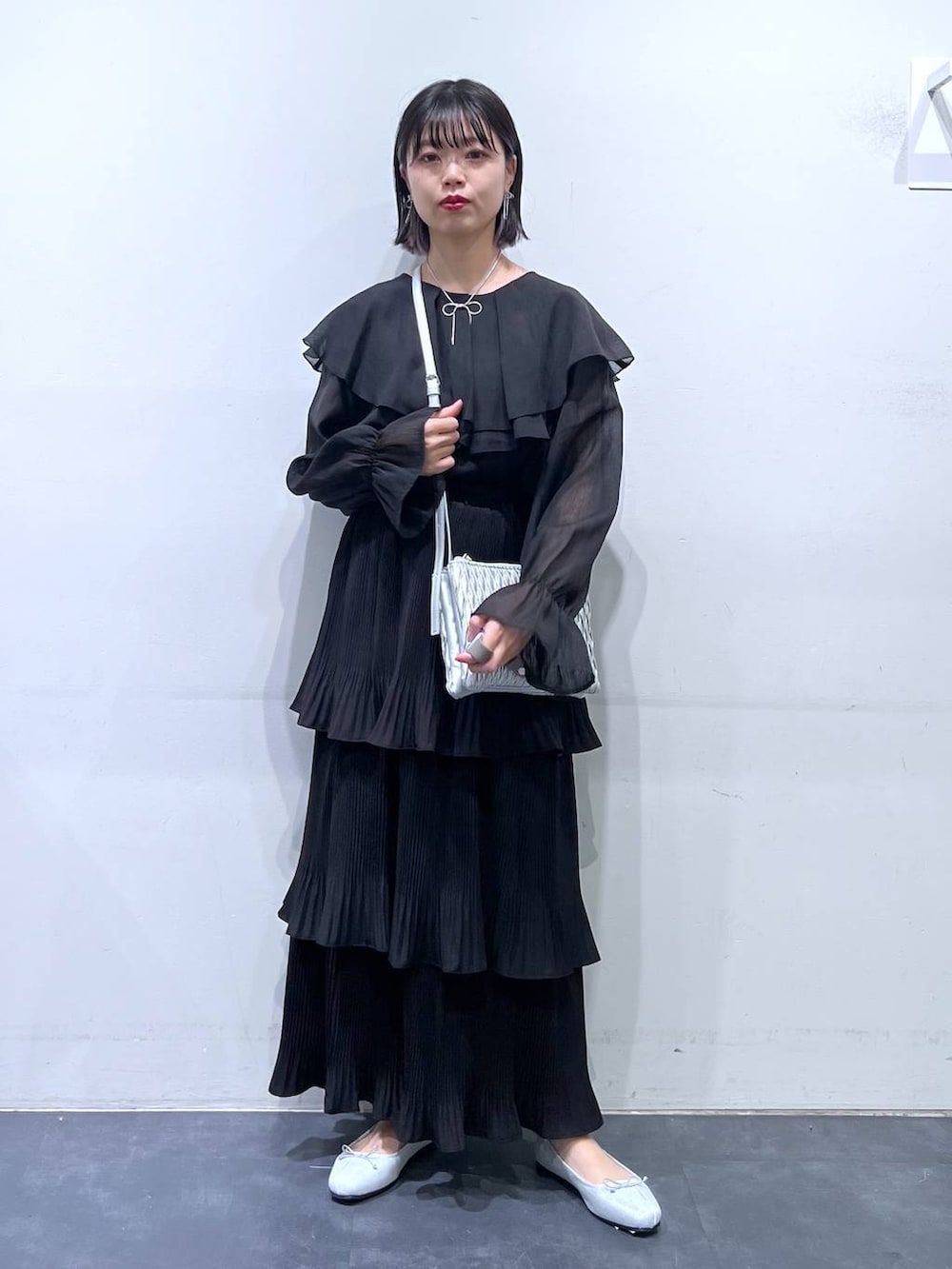 その他のショルダーバッグ、シルバー系のバレエシューズ、ブラック系のスカートを着用したレディースの春コーディネートの2枚目の写真