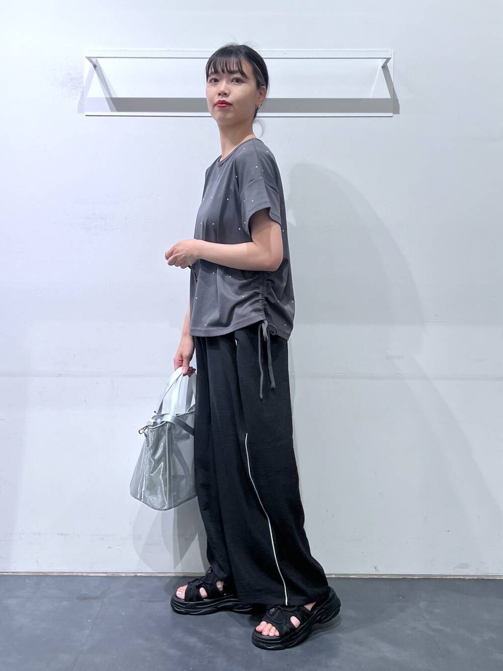 ブラック系のサンダル、ブラック系のその他パンツ、シルバー系のトートバッグを着用したレディースの夏コーディネートの3枚目の写真