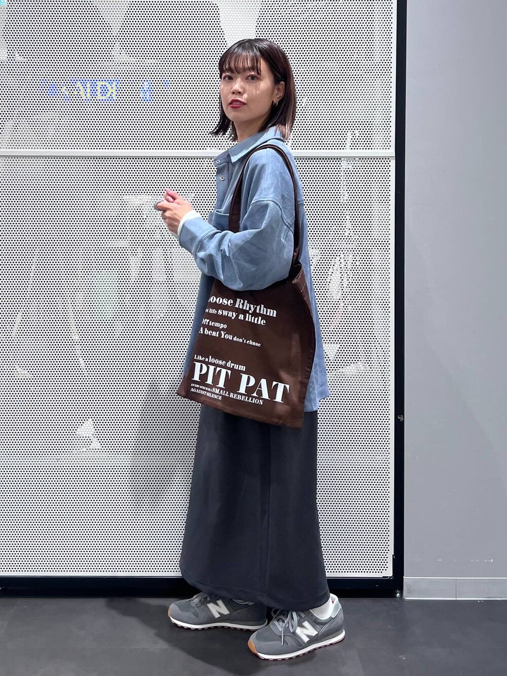 グレー系のスニーカー、ホワイト系のTシャツ/カットソー、グレー系のスカートを着用したレディースの秋コーディネートの4枚目の写真