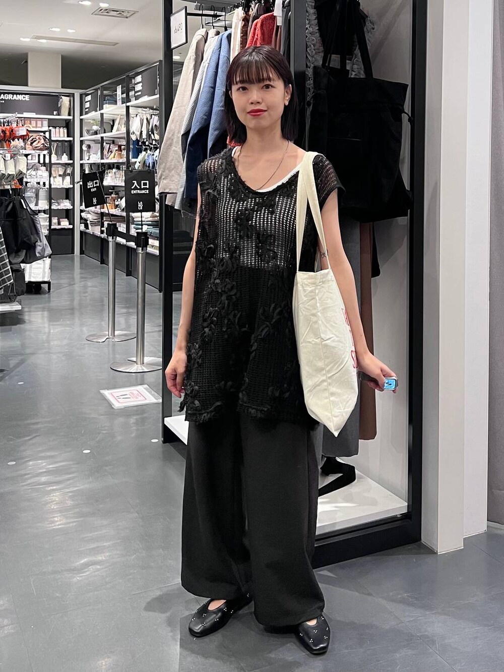 ブラック系のその他パンツ、ホワイト系のタンクトップ、ホワイト系のトートバッグを着用したレディースの秋コーディネートの2枚目の写真