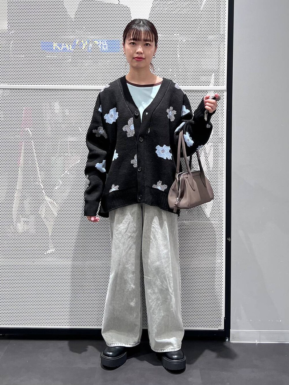 グレー系のデニムパンツ、ブラック系のブーツ、ブラック系のカーディガン/ボレロを着用したレディースの秋コーディネートの2枚目の写真