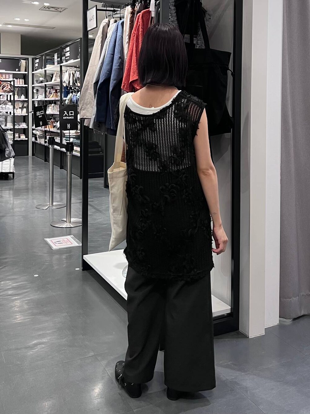 ブラック系のその他パンツ、ホワイト系のタンクトップ、ホワイト系のトートバッグを着用したレディースの秋コーディネートの4枚目の写真