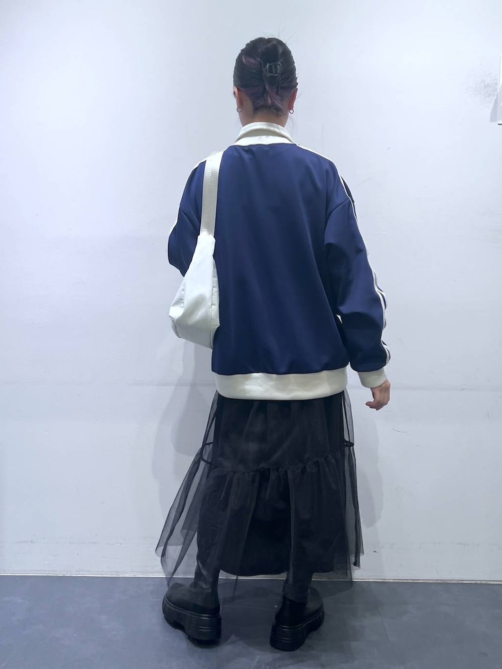 ブラック系のブーツ、ホワイト系のショルダーバッグ、ブルー系のスウェットを着用したレディースの冬コーディネートの5枚目の写真