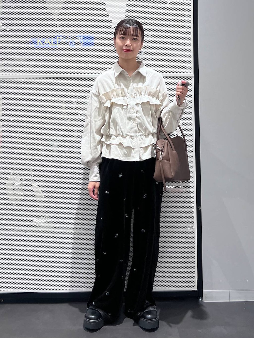 ブラウン系のボストンバッグ、ブラック系のブーツ、ベージュ系のシャツ/ブラウスを着用したレディースの秋コーディネートの2枚目の写真