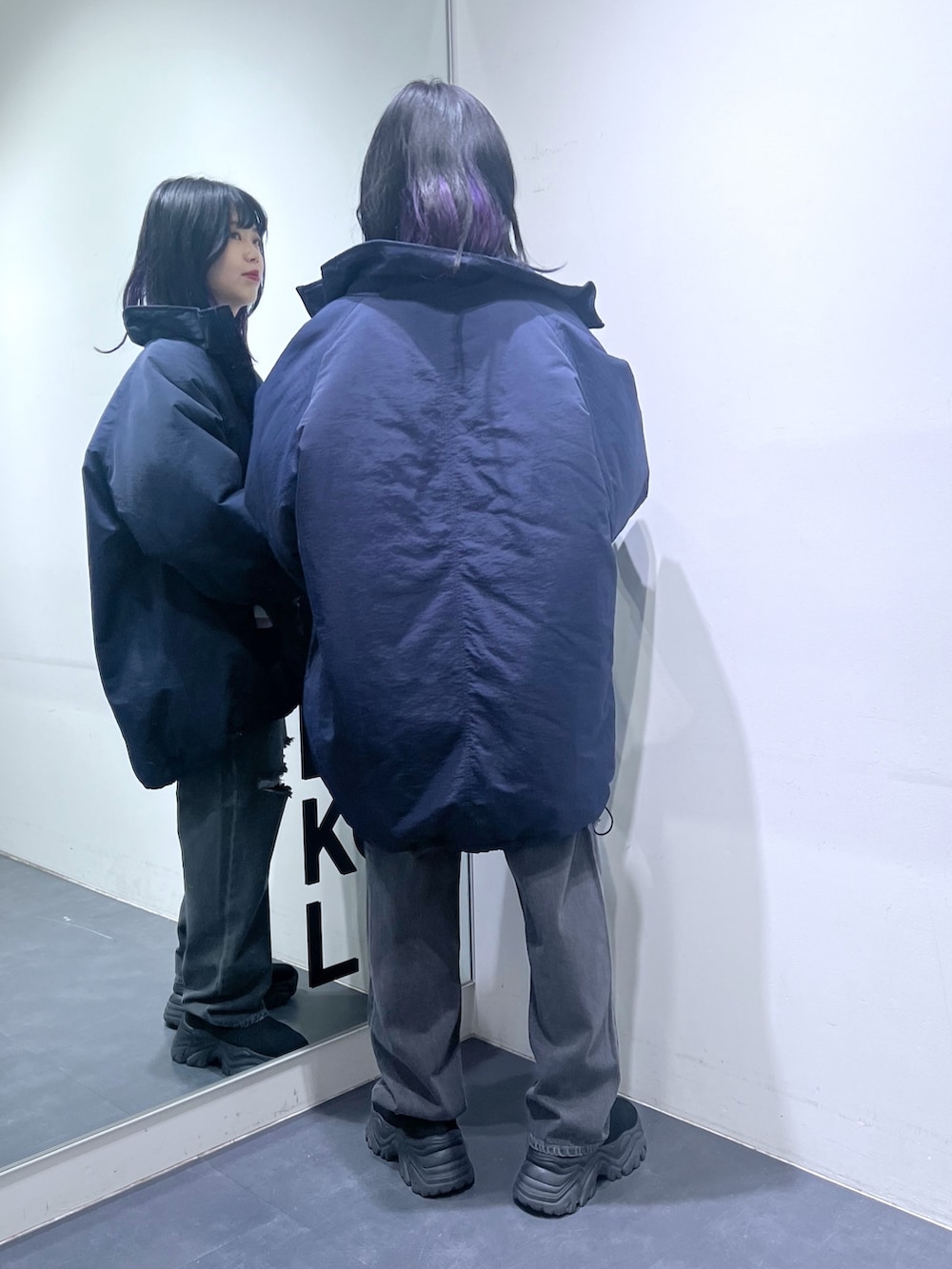 ブルー系のニット/セーター、ブルー系のナイロンジャケット、グレー系のデニムパンツを着用したレディースの冬コーディネートの4枚目の写真