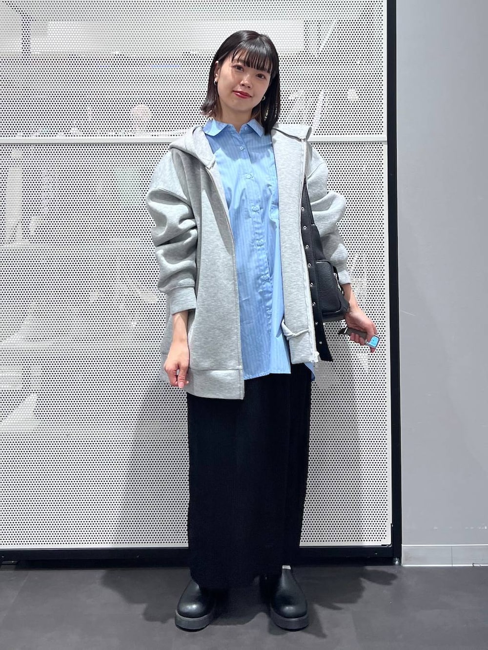 グレー系のパーカー、ブラック系のショルダーバッグ、ブラック系のサンダルを着用したレディースの春コーディネートの2枚目の写真