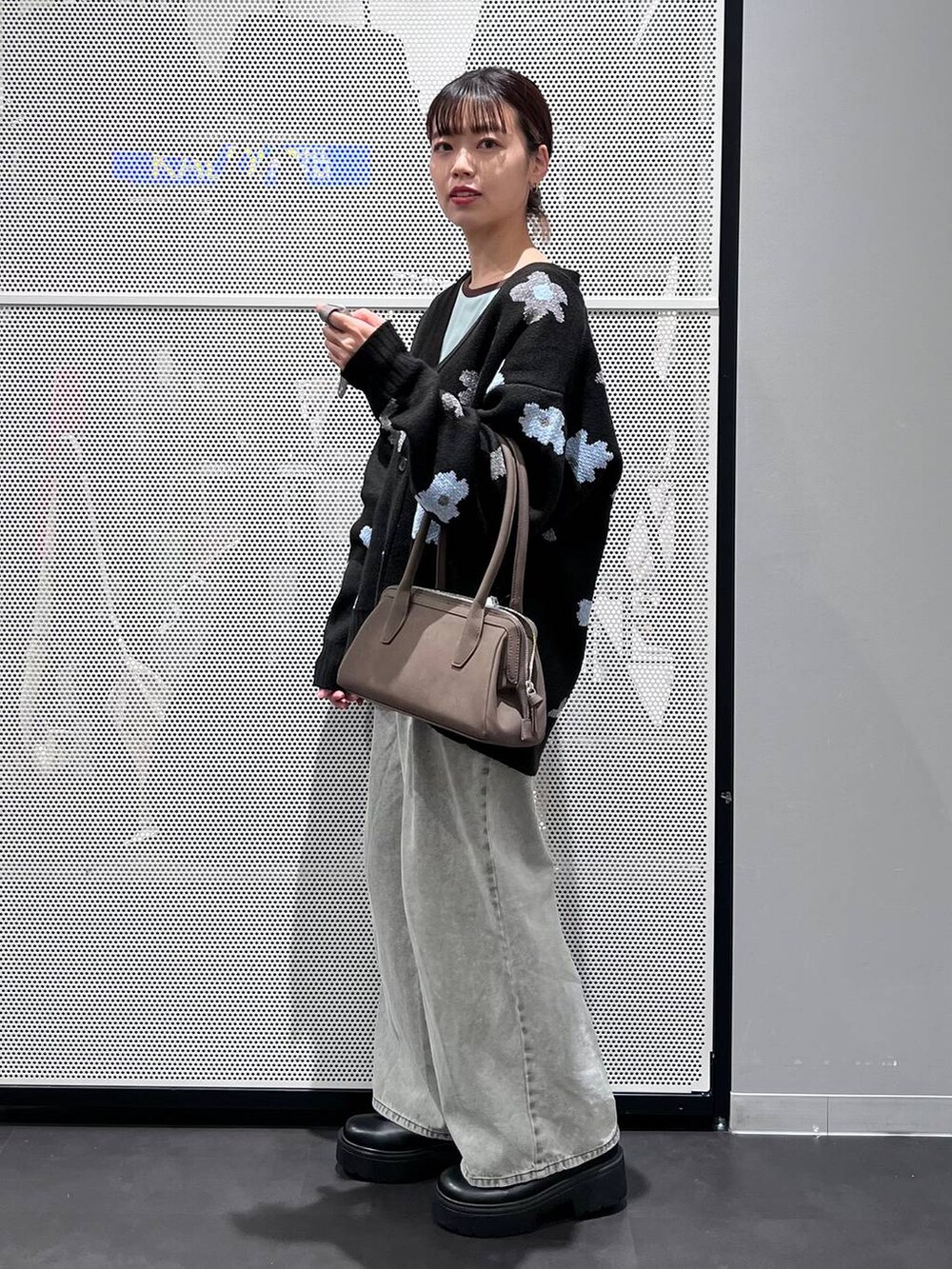 グレー系のデニムパンツ、ブラック系のブーツ、ブラック系のカーディガン/ボレロを着用したレディースの秋コーディネートの3枚目の写真