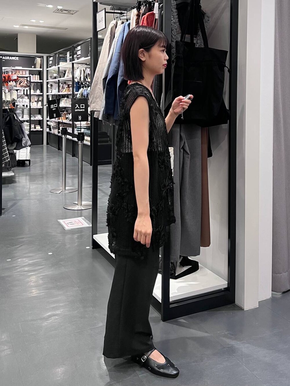 ブラック系のその他パンツ、ホワイト系のタンクトップ、ホワイト系のトートバッグを着用したレディースの秋コーディネートの5枚目の写真