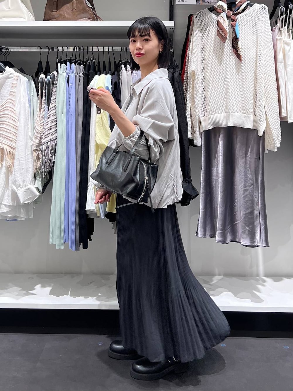 ブラック系のボストンバッグ、ブラック系のサンダル、グレー系のブルゾンを着用したレディースの春コーディネートの4枚目の写真