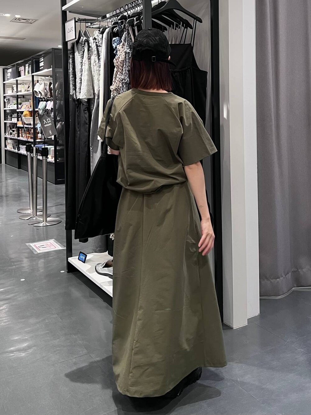 ブラック系のトートバッグ、ブラック系のスニーカー、グリーン系のTシャツ/カットソーを着用したレディースの春コーディネートの5枚目の写真