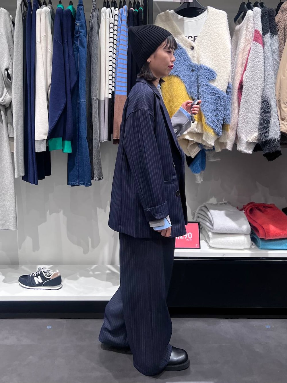 ブラウン系のボストンバッグ、ブルー系のスラックス、ブルー系のテーラードジャケットを着用したレディースの冬コーディネートの3枚目の写真