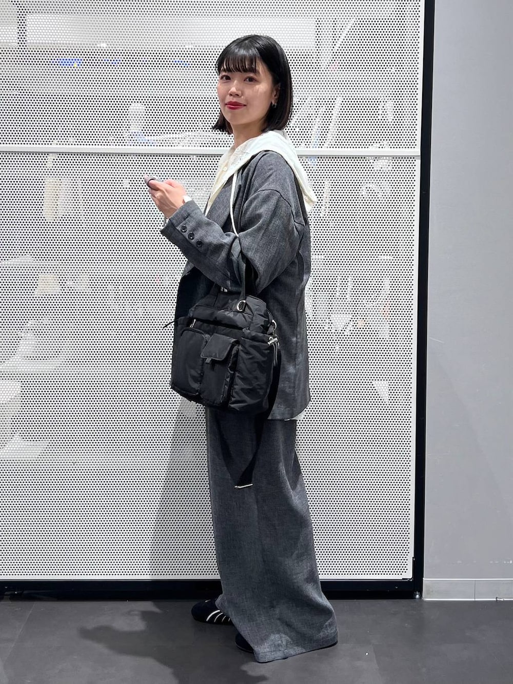 ブラック系のスニーカー、ブラック系のトートバッグ、ホワイト系のシャツ/ブラウスを着用したレディースの春コーディネートの3枚目の写真