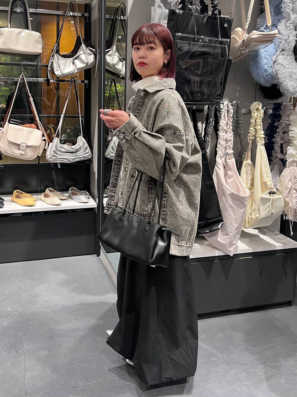 ブラック系のトートバッグ、シルバー系のパンプス、ブラック系のデニムジャケットを着用したレディースの春コーディネートの4枚目の写真