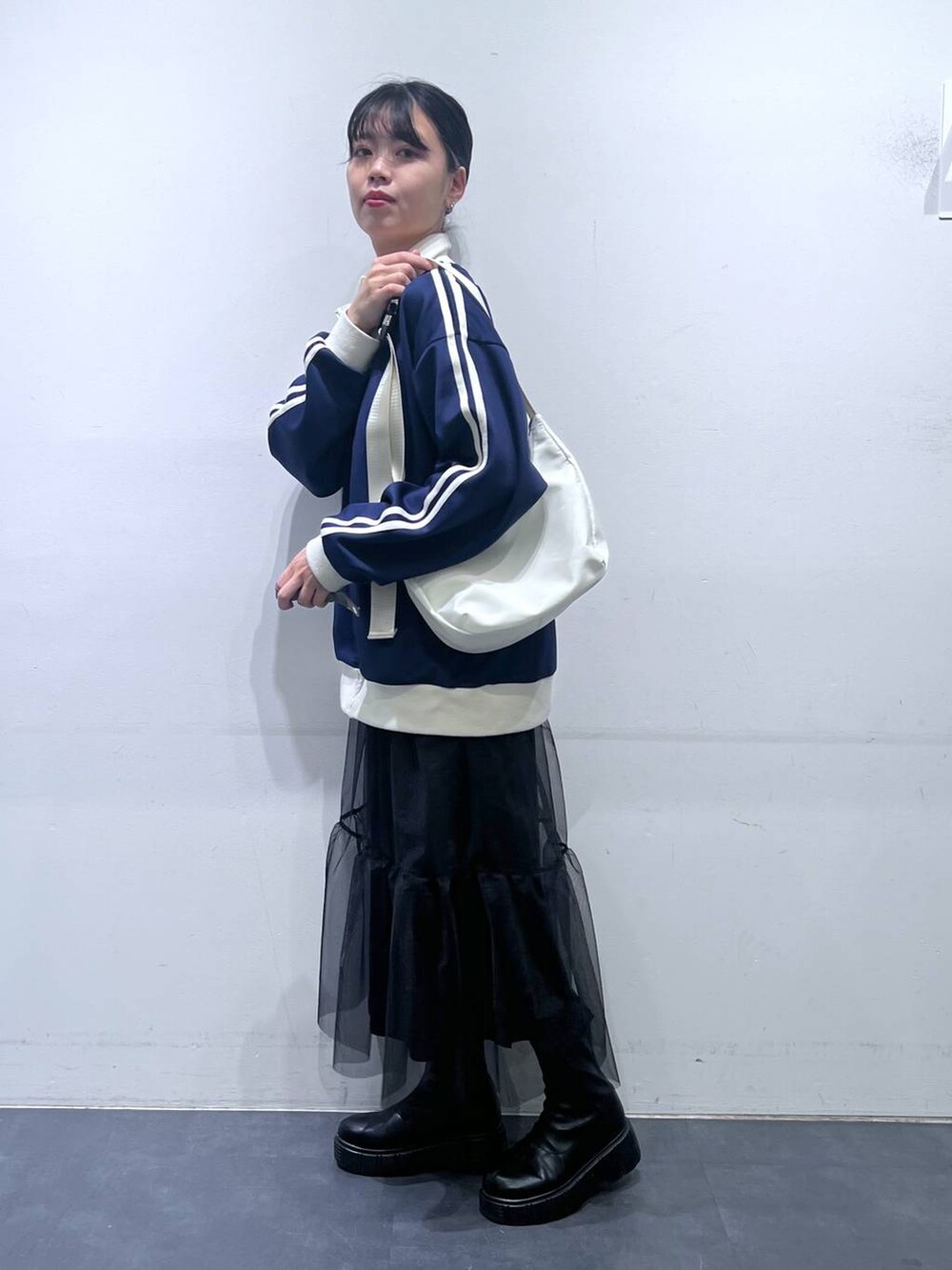 ブラック系のブーツ、ホワイト系のショルダーバッグ、ブルー系のスウェットを着用したレディースの冬コーディネートの4枚目の写真