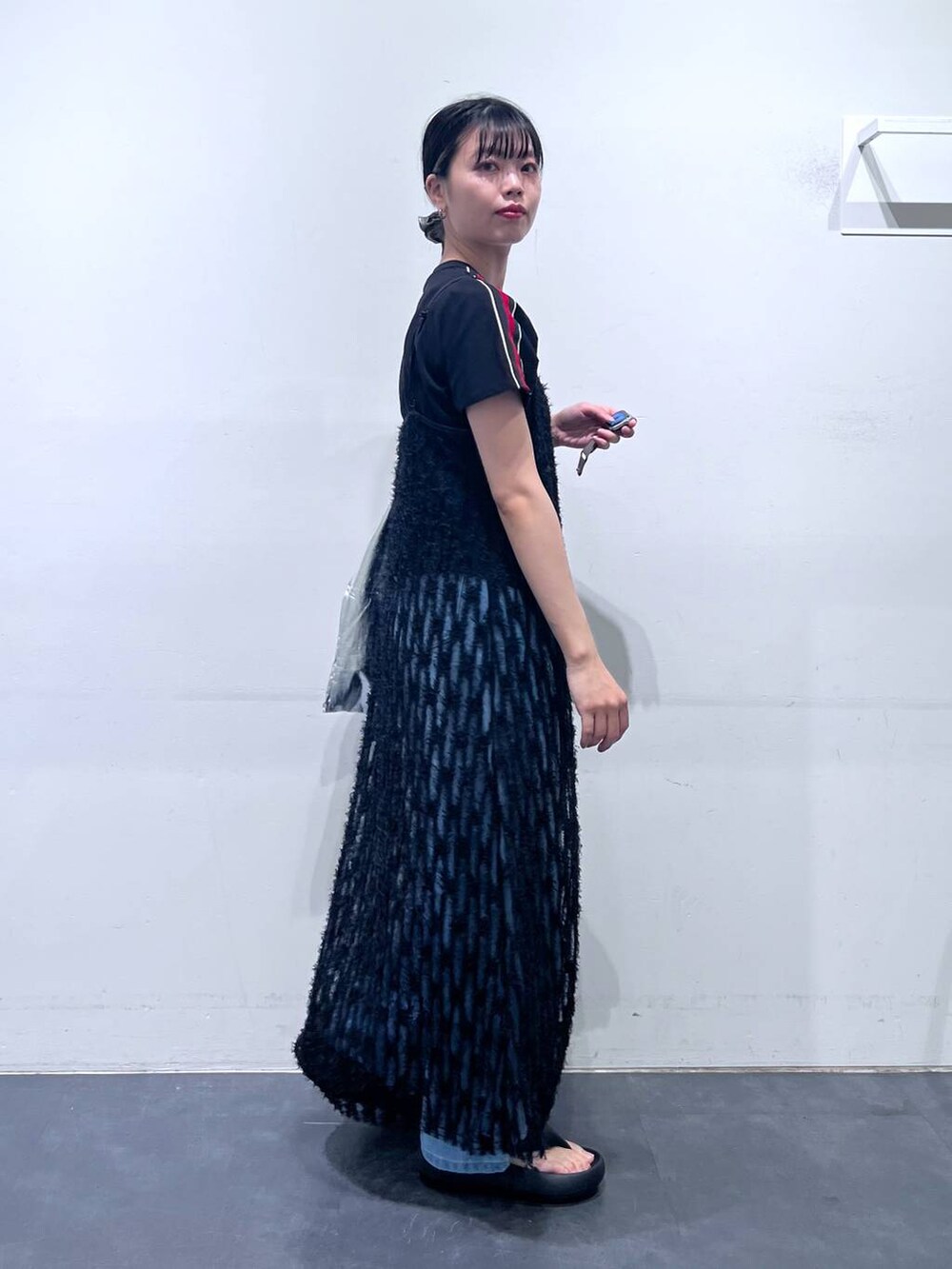 ブラック系のサンダル、シルバー系のトートバッグ、ブルー系のデニムパンツを着用したレディースの春コーディネートの4枚目の写真