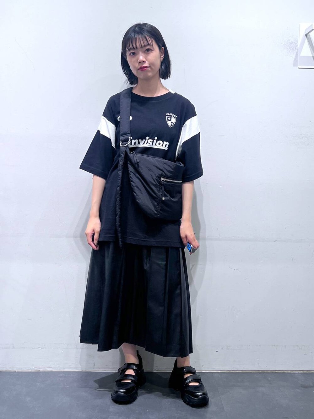 ブラック系のショルダーバッグ、ブラック系のTシャツ/カットソー、ブラック系のスニーカーを着用したレディースの夏コーディネートの2枚目の写真