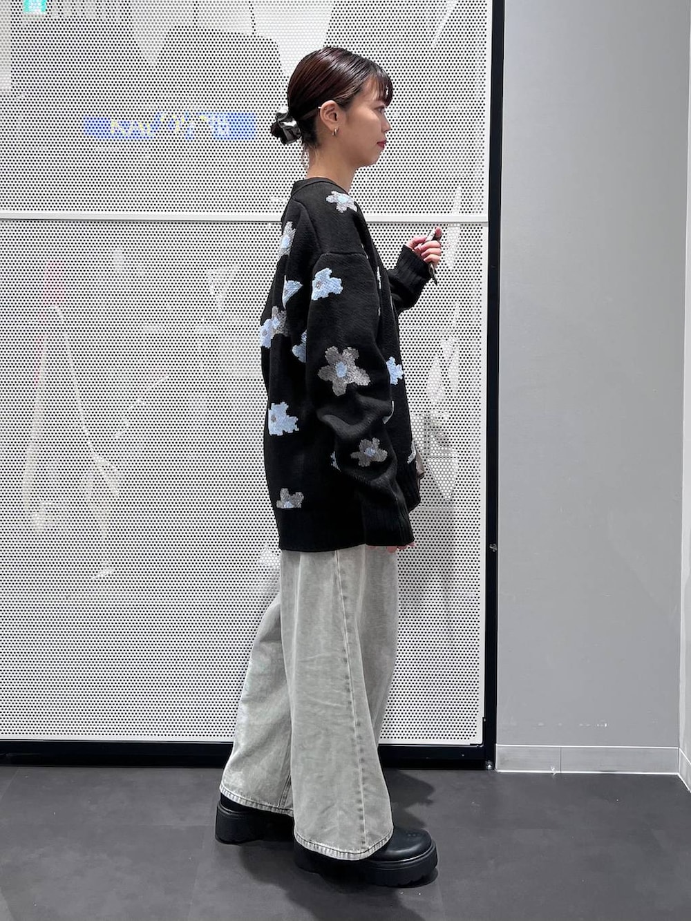 グレー系のデニムパンツ、ブラック系のブーツ、ブラック系のカーディガン/ボレロを着用したレディースの秋コーディネートの5枚目の写真