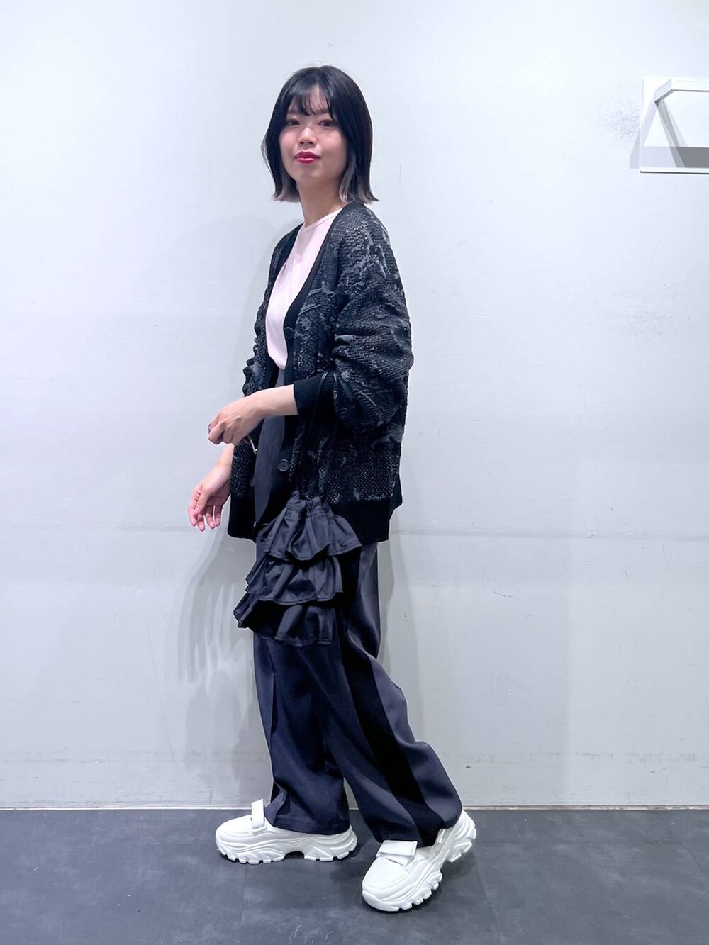 ホワイト系のスニーカー、ブラック系のショルダーバッグ、グレー系のその他パンツを着用したレディースの春コーディネートの2枚目の写真