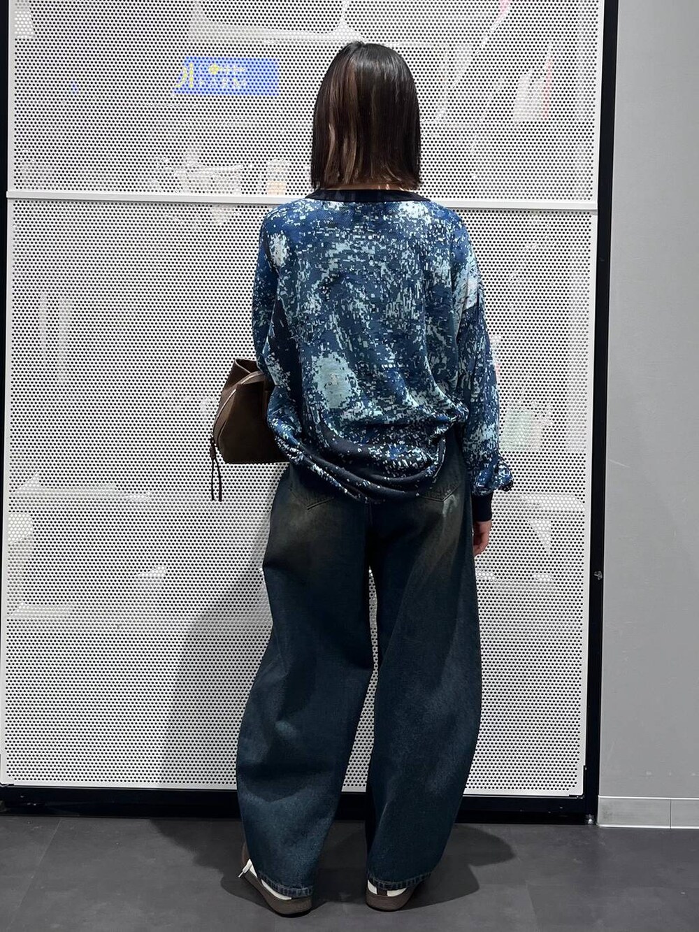 ブルー系のデニムパンツ、ホワイト系のスニーカー、ブラウン系のボストンバッグを着用したレディースの冬コーディネートの5枚目の写真