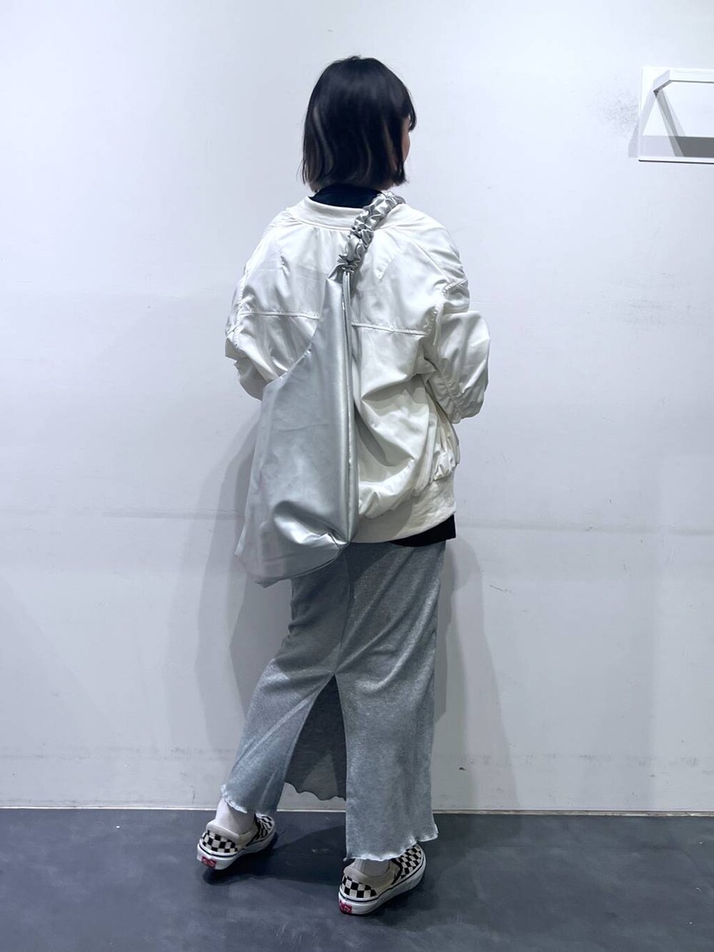 グレー系のスカート、ベージュ系のMA-1、ブラック系のTシャツ/カットソーを着用したレディースの春コーディネートの4枚目の写真